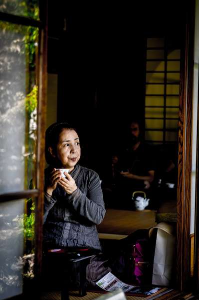 A woman sips tea at a teahouse in Kyoto