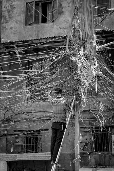A man fixes a mass of cabling in Kathmandu, Nepal