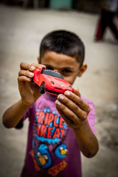 A boy shows off his toy car in Kathmandu, Nepal